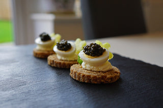 Rye bread rounds with quail egg and caviar